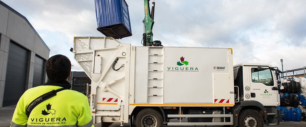 Operario de Viguera junto a un camión compactador durante una recogida de cartón